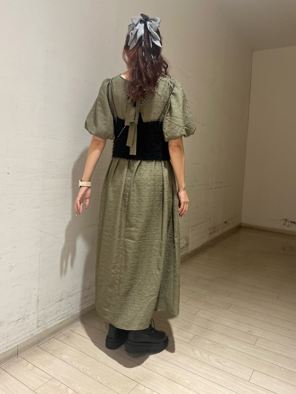 グリーン系のワンピース、ブラック系のシャツ/ブラウス、ブラウン系のハンドバッグを着用したレディースの秋コーディネートの2枚目の写真