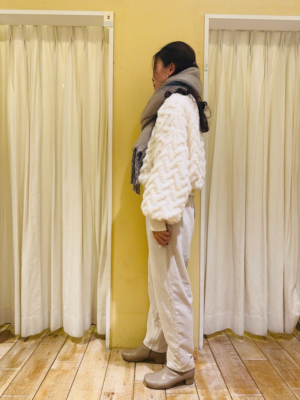 ベージュ系のその他アウター、ホワイト系のニット/セーター、ホワイト系のその他パンツを着用したレディースの冬コーディネートの3枚目の写真