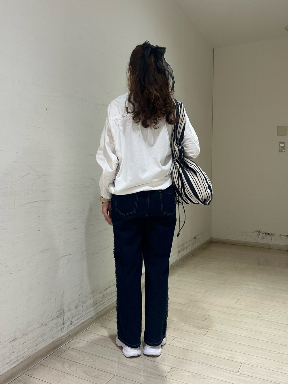 ホワイト系のTシャツ/カットソー、ブラック系のTシャツ/カットソー、ブルー系のハンドバッグを着用したレディースの春コーディネートの2枚目の写真