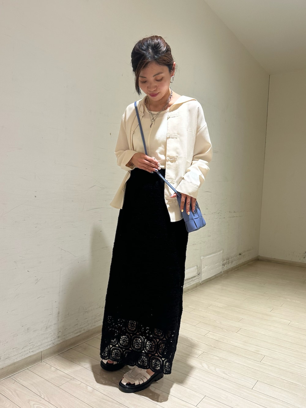 ホワイト系のシャツ/ブラウス、ホワイト系のタンクトップ、ブルー系のショルダーバッグを着用したレディースの春コーディネートの4枚目の写真