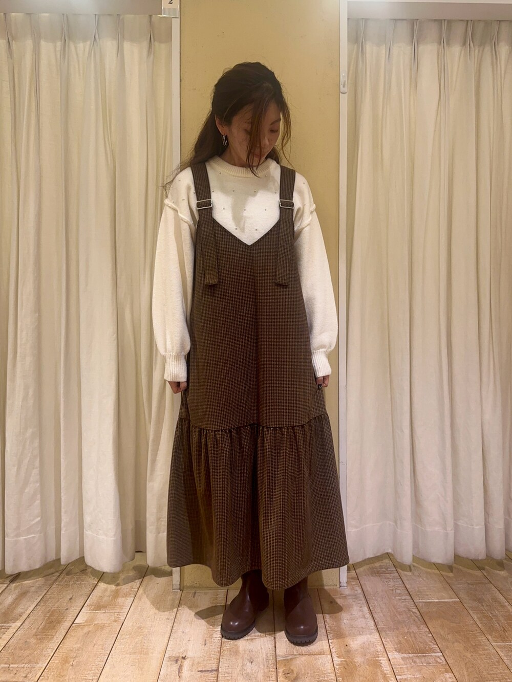 ホワイト系のニット/セーター、ブラウン系のワンピース、ホワイト系のハンドバッグを着用したレディースの秋コーディネートの3枚目の写真