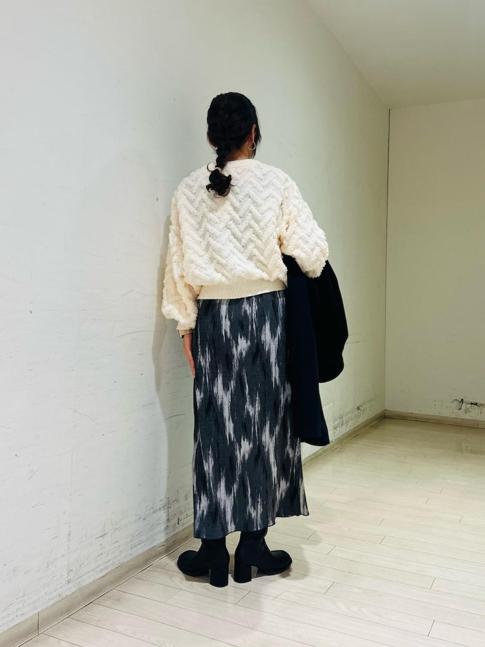 ブルー系のステンカラーコート、ホワイト系のニット/セーター、ブラック系のドレスシューズを着用したレディースの冬コーディネートの4枚目の写真