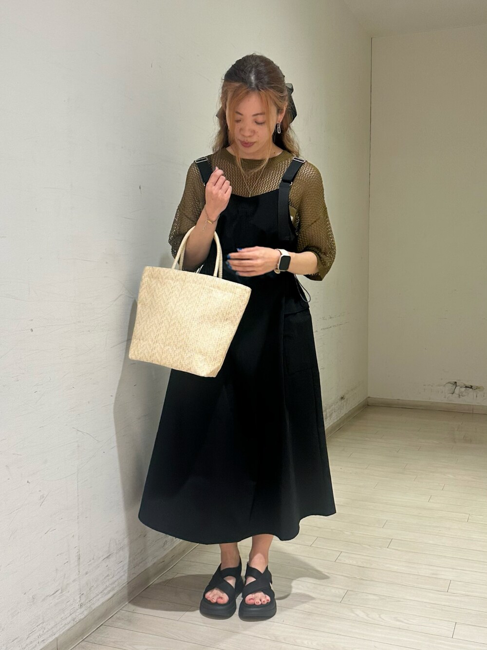 グリーン系のニット/セーター、ホワイト系のハンドバッグ、ブラック系のドレスシューズを着用したレディースの春コーディネートの5枚目の写真