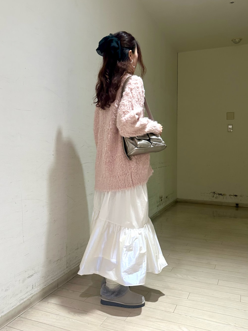 ピンク系のカーディガン/ボレロ、ベージュ系のキャミソール、シルバー系のハンドバッグを着用したレディースの秋コーディネートの2枚目の写真