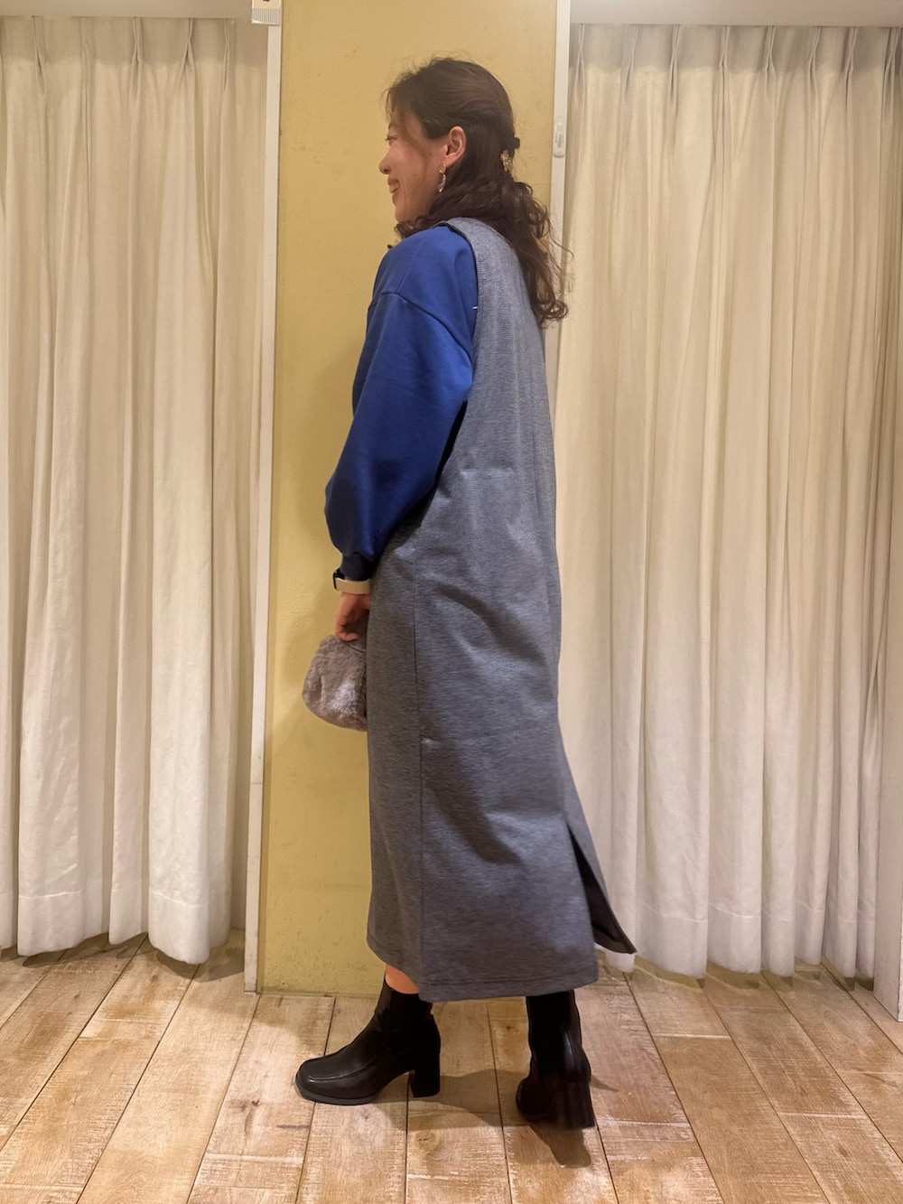 グレー系のワンピース、ブラック系のドレスシューズ、グレー系のハンドバッグを着用したレディースの秋コーディネートの4枚目の写真