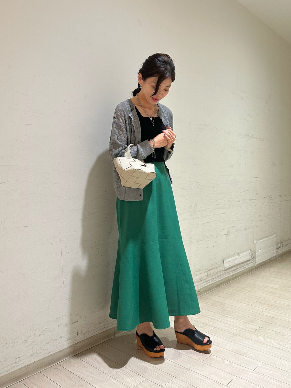 グレー系のカーディガン/ボレロ、ブラック系のTシャツ/カットソー、グリーン系のスカートを着用したレディースの春コーディネートの4枚目の写真