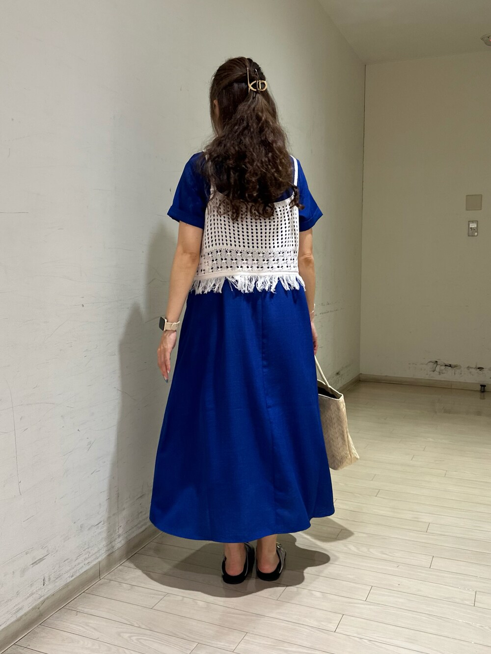 ホワイト系のニット/セーター、ホワイト系のハンドバッグ、シルバー系のドレスシューズを着用したレディースの夏コーディネートの2枚目の写真