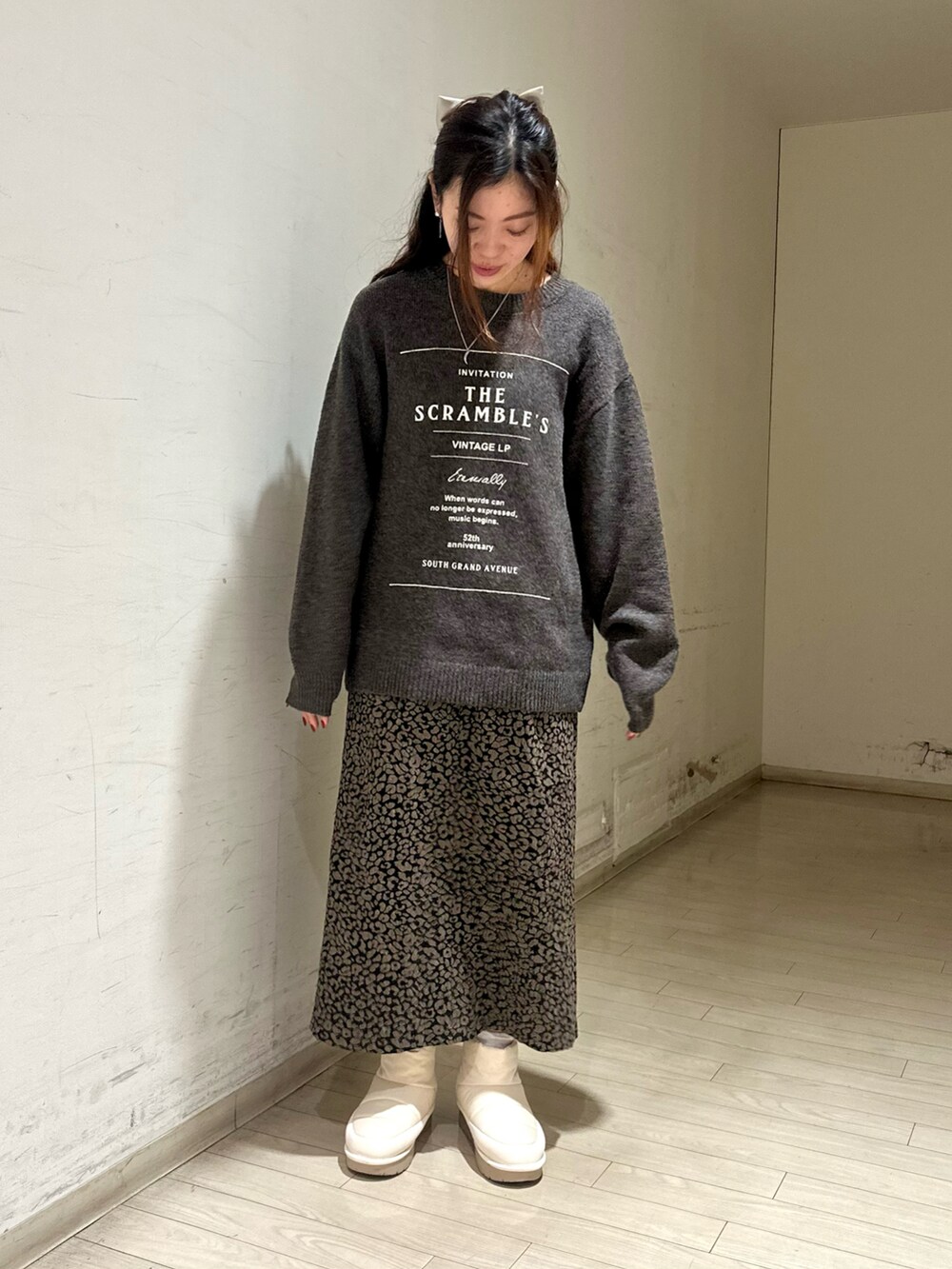 ホワイト系のブルゾン、ブラウン系のニット/セーター、ブラウン系のスカートを着用したレディースの冬コーディネートの3枚目の写真