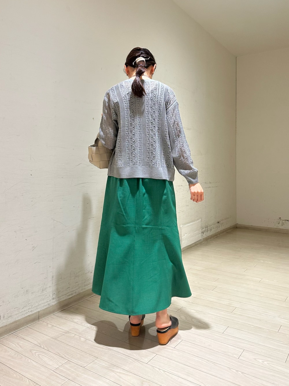 グレー系のカーディガン/ボレロ、ブラック系のTシャツ/カットソー、グリーン系のスカートを着用したレディースの春コーディネートの3枚目の写真