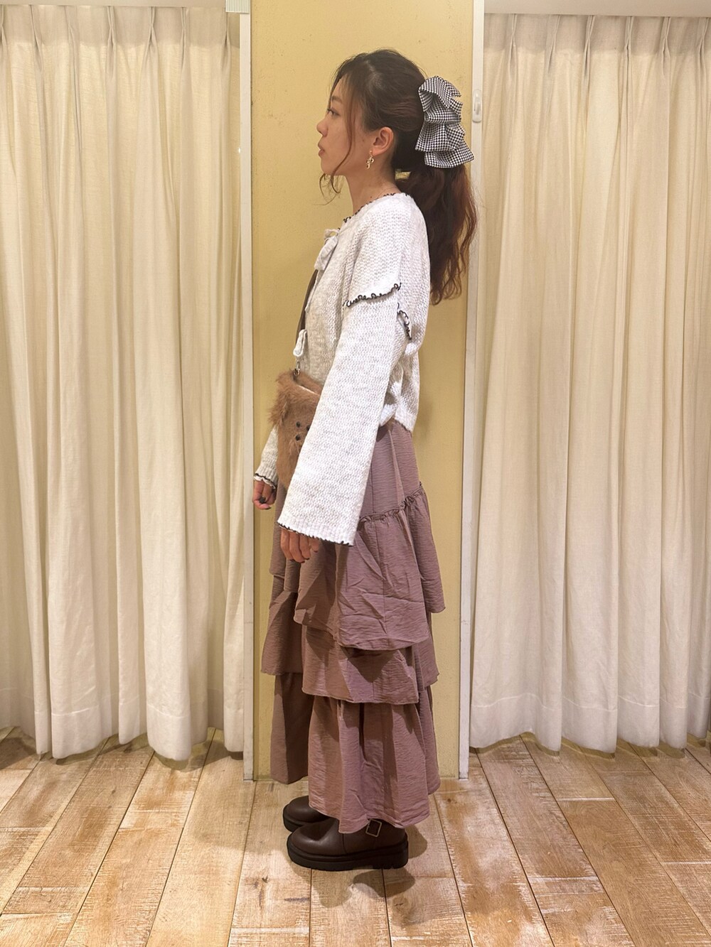 ホワイト系のカーディガン/ボレロ、ホワイト系のTシャツ/カットソー、ブラウン系のハンドバッグを着用したレディースの秋コーディネートの2枚目の写真