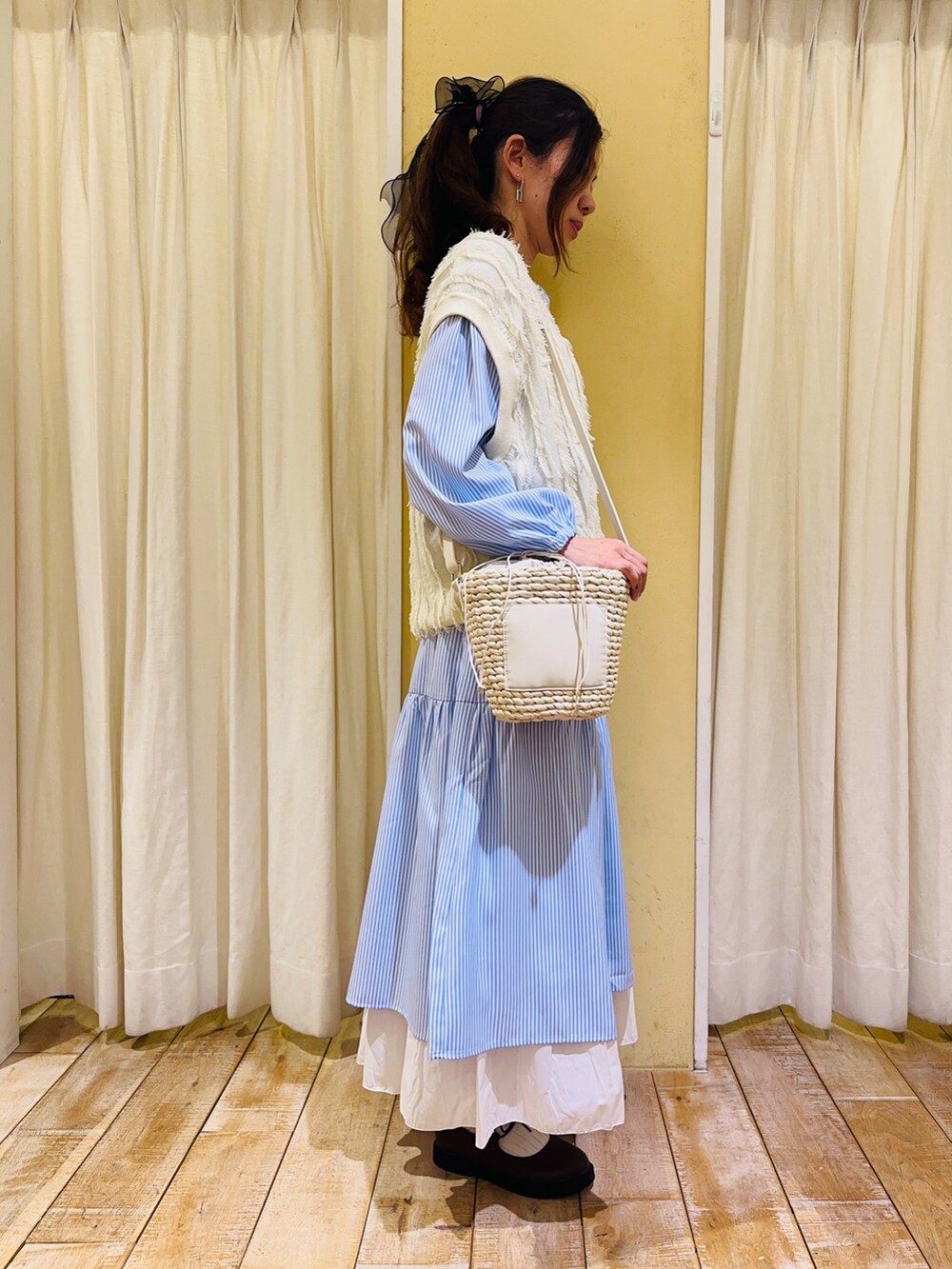 ブルー系のワンピース、ホワイト系のハンドバッグ、ホワイト系のスカートを着用したレディースの春コーディネートの2枚目の写真