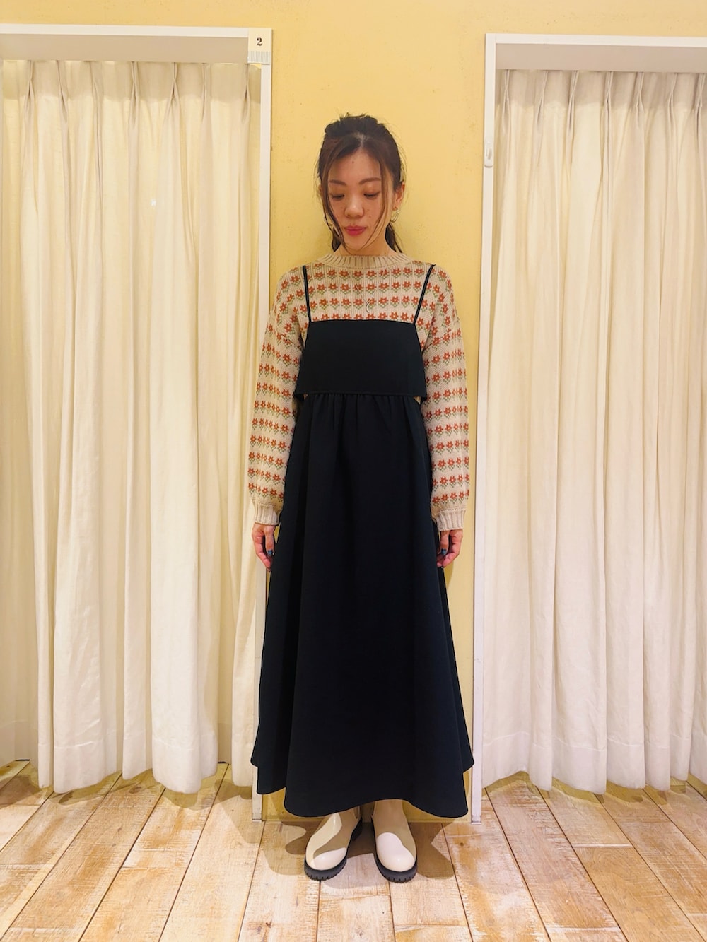 ホワイト系のノーカラージャケット、ベージュ系のニット/セーター、ブラック系のワンピースを着用したレディースの冬コーディネートの4枚目の写真