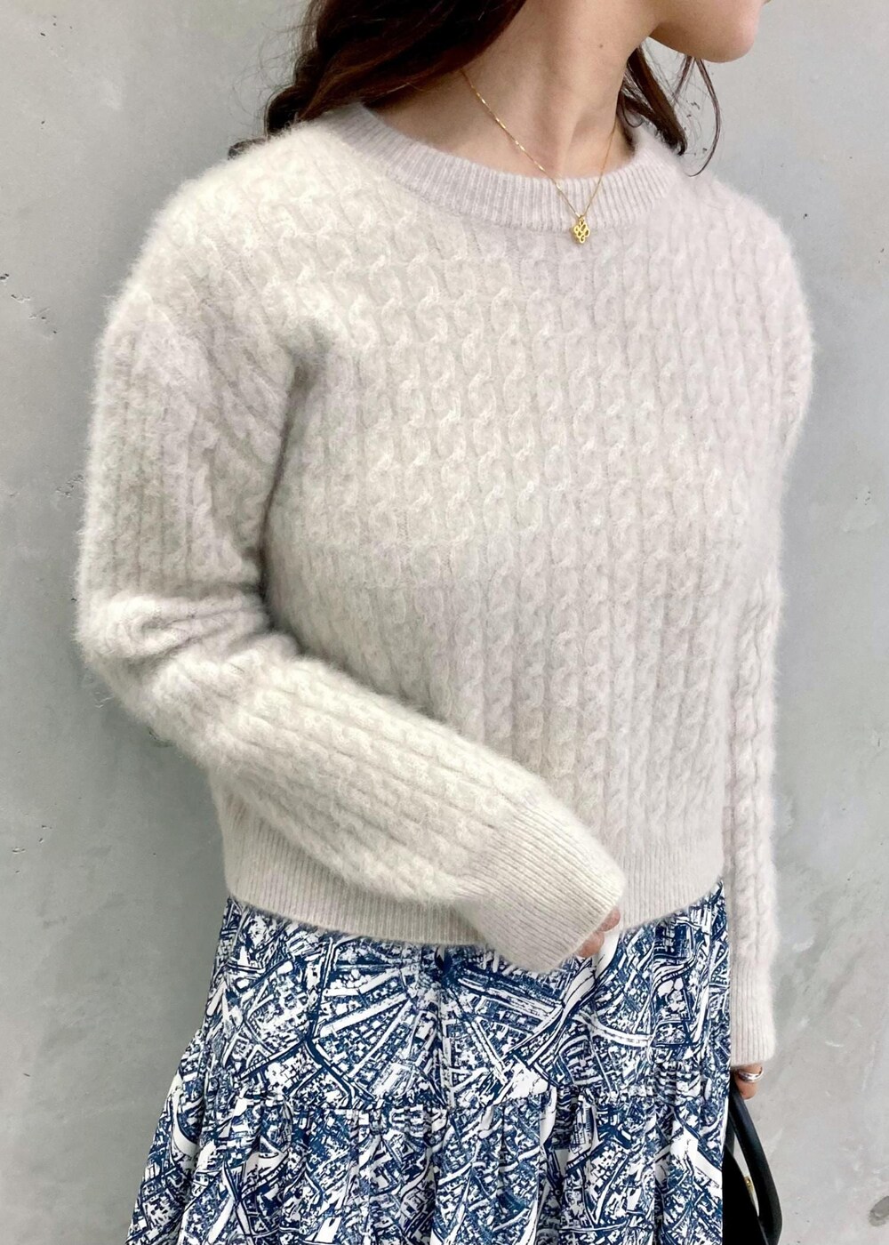 ブラック系のショルダーバッグ、ブラック系のパンプス、ブルー系のスカートを着用したレディースの秋コーディネートの5枚目の写真