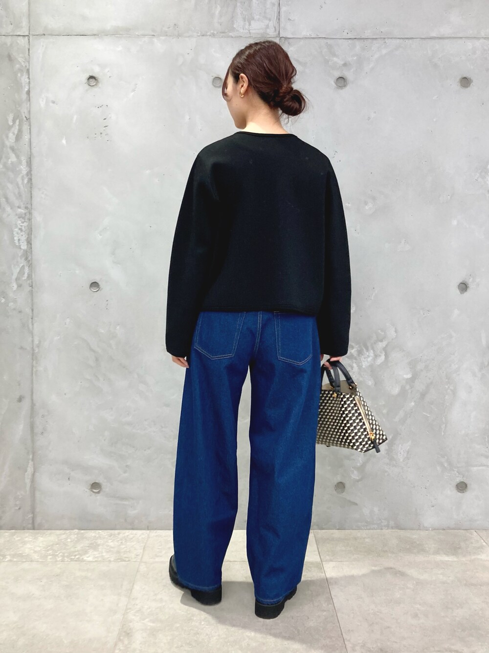 ブラック系のカーディガン/ボレロ、ブルー系のデニムパンツ、ブラック系のショルダーバッグを着用したレディースの秋コーディネートの3枚目の写真