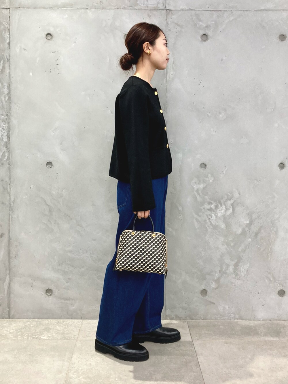 ブラック系のカーディガン/ボレロ、ブルー系のデニムパンツ、ブラック系のショルダーバッグを着用したレディースの秋コーディネートの2枚目の写真