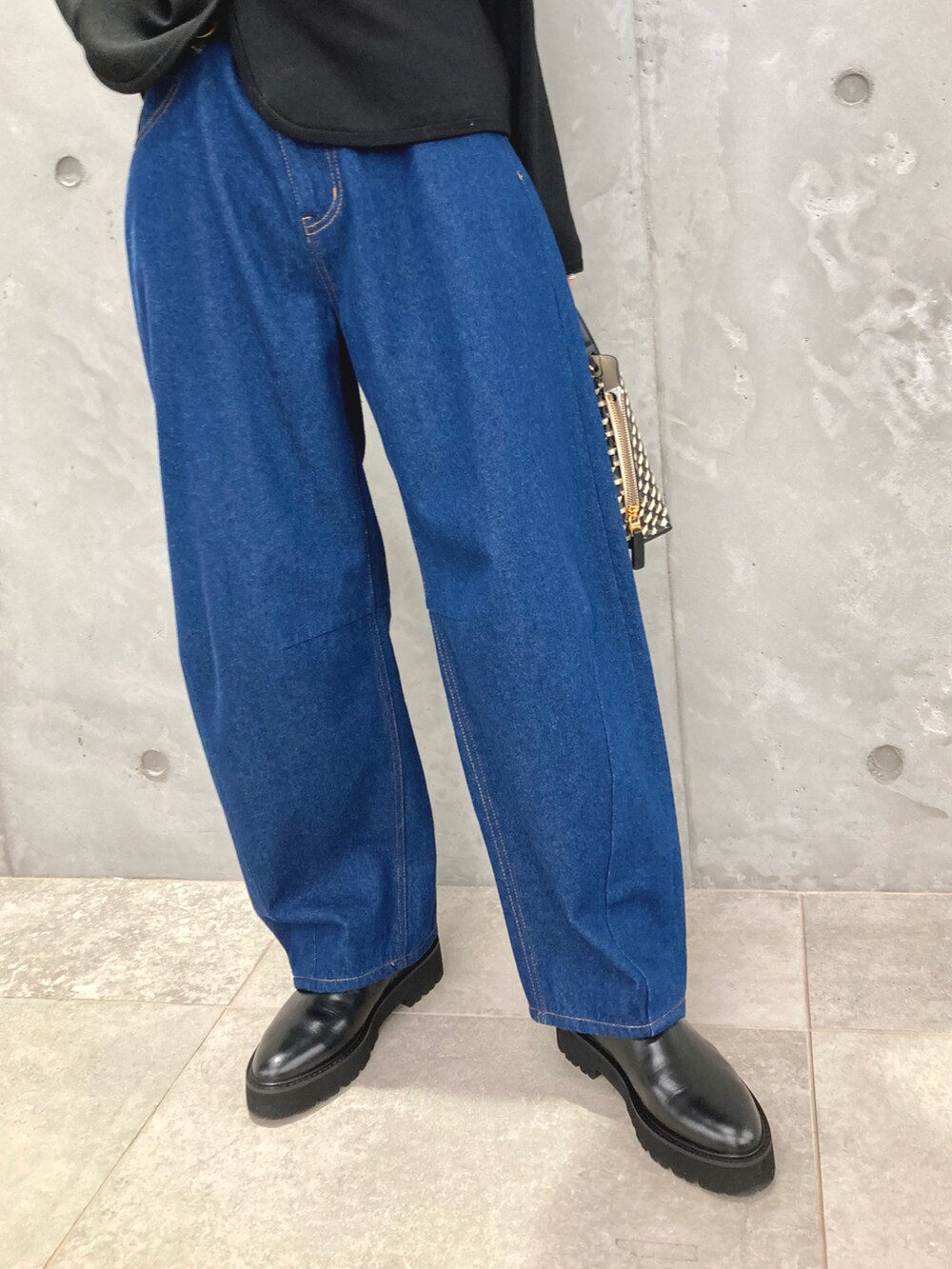 ブラック系のカーディガン/ボレロ、ブルー系のデニムパンツ、ブラック系のショルダーバッグを着用したレディースの秋コーディネートの5枚目の写真