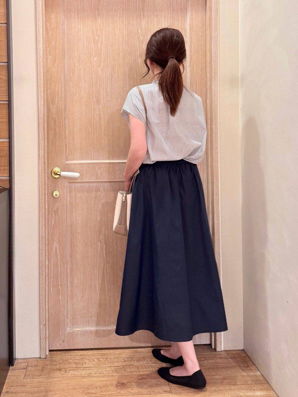 ホワイト系のシャツ/ブラウス、ブルー系のスカート、ベージュ系のショルダーバッグを着用したレディースの夏コーディネートの4枚目の写真