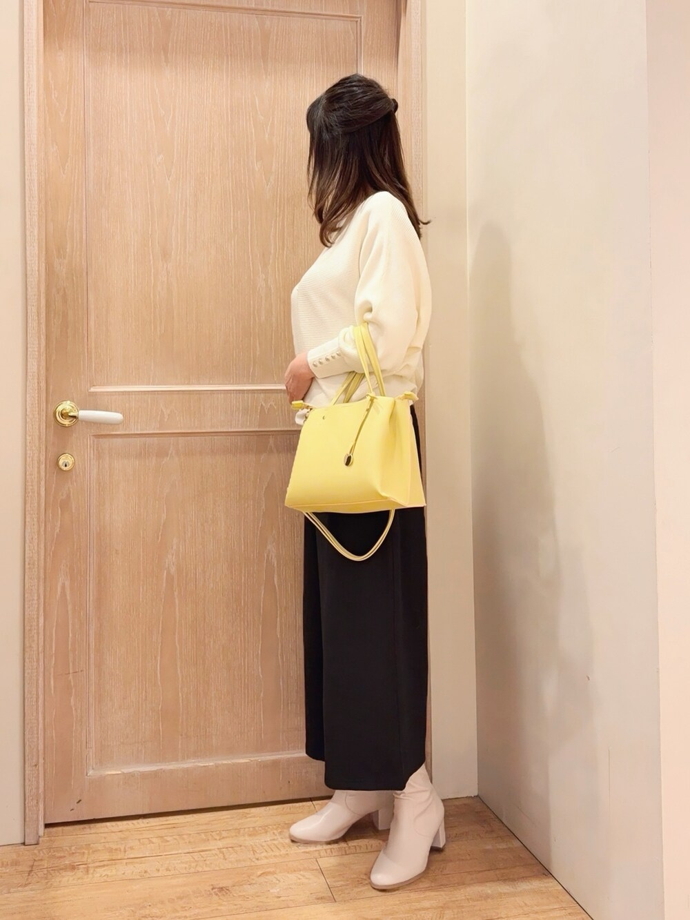 ホワイト系のニット/セーター、ブラック系のその他パンツ、イエロー系のトートバッグを着用したレディースの冬コーディネートの2枚目の写真