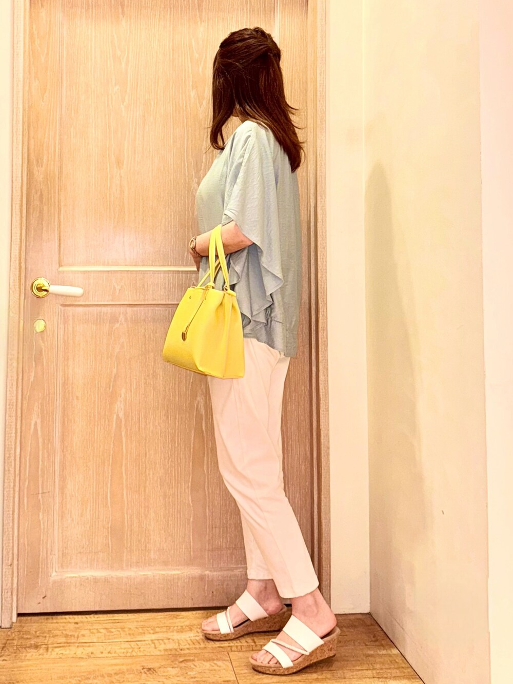 グリーン系のシャツ/ブラウス、イエロー系のトートバッグ、ホワイト系のデニムパンツを着用したレディースの春コーディネートの3枚目の写真