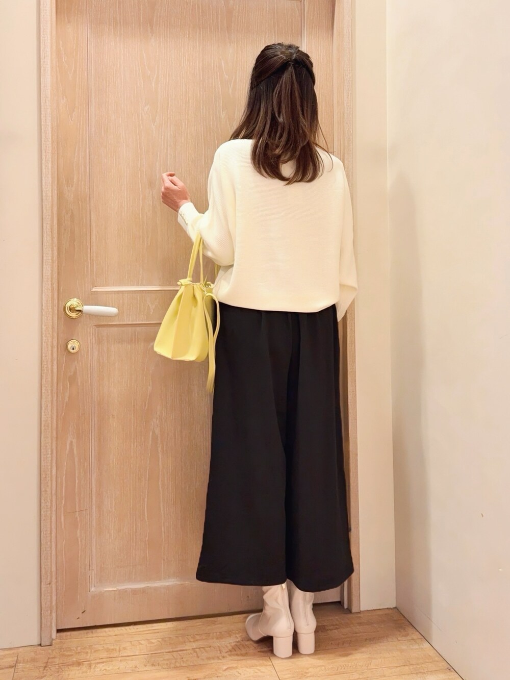 ホワイト系のニット/セーター、ブラック系のその他パンツ、イエロー系のトートバッグを着用したレディースの冬コーディネートの3枚目の写真