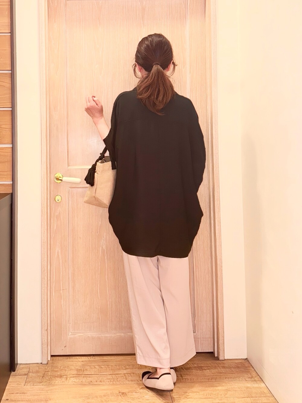 ブラック系のチュニック、ベージュ系のその他パンツ、ブラック系のトートバッグを着用したレディースの夏コーディネートの3枚目の写真