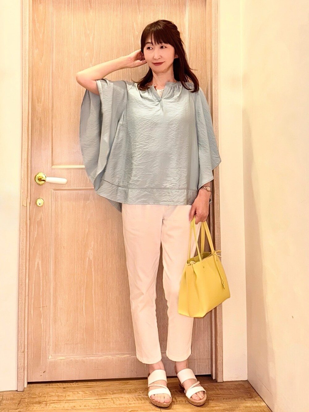 グリーン系のシャツ/ブラウス、イエロー系のトートバッグ、ホワイト系のデニムパンツを着用したレディースの春コーディネートの2枚目の写真