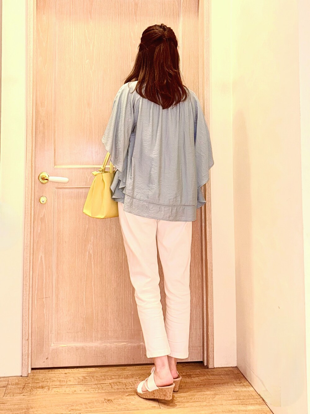 グリーン系のシャツ/ブラウス、イエロー系のトートバッグ、ホワイト系のデニムパンツを着用したレディースの春コーディネートの4枚目の写真