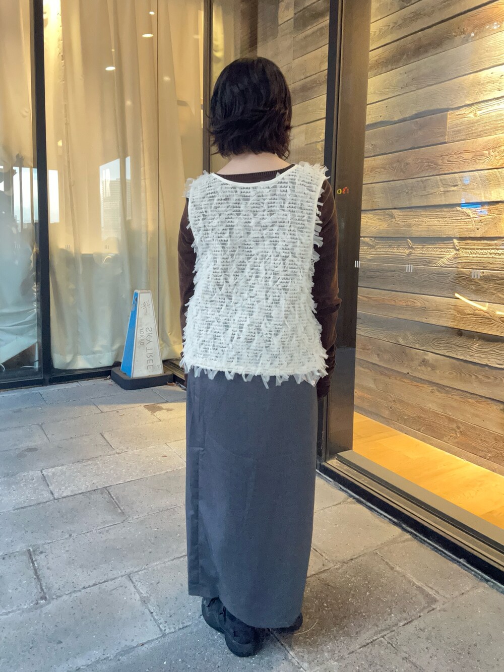 ホワイト系のベスト、ブラウン系のTシャツ/カットソー、グレー系のスカートを着用したレディースの秋コーディネートの3枚目の写真