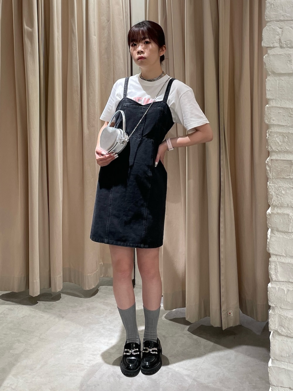 ブラック系のワンピース、ホワイト系のTシャツ/カットソー、シルバー系のショルダーバッグを着用したレディースの春コーディネートの3枚目の写真