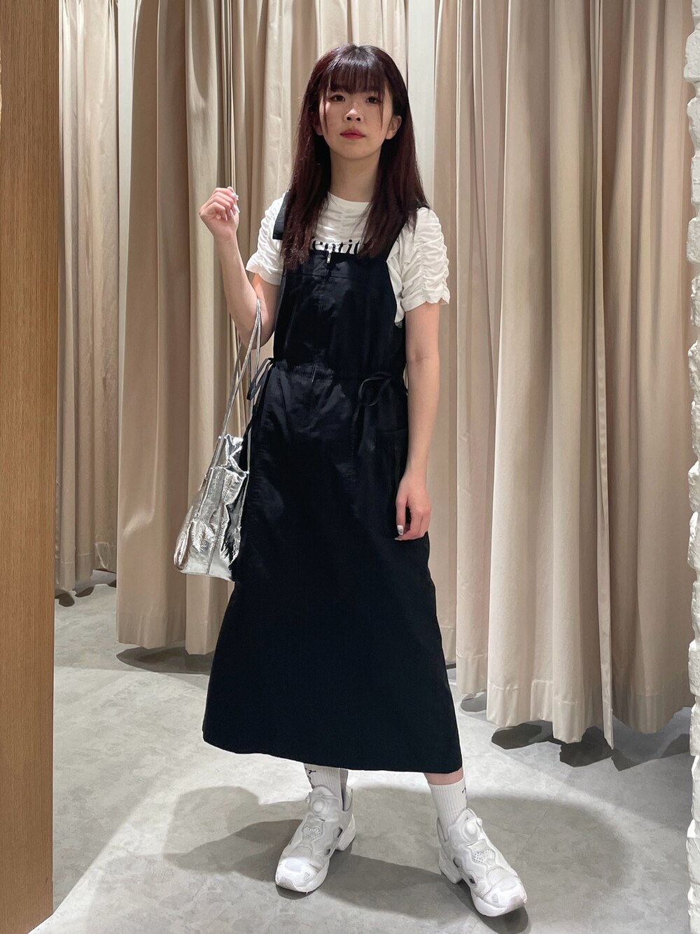 ブラック系のワンピース、シルバー系のショルダーバッグ、ホワイト系のTシャツ/カットソーを着用したレディースの春コーディネートの2枚目の写真