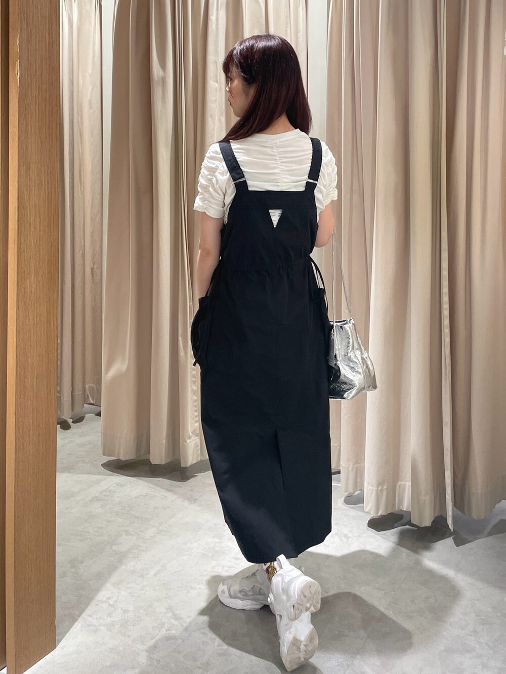 ブラック系のワンピース、シルバー系のショルダーバッグ、ホワイト系のTシャツ/カットソーを着用したレディースの春コーディネートの3枚目の写真