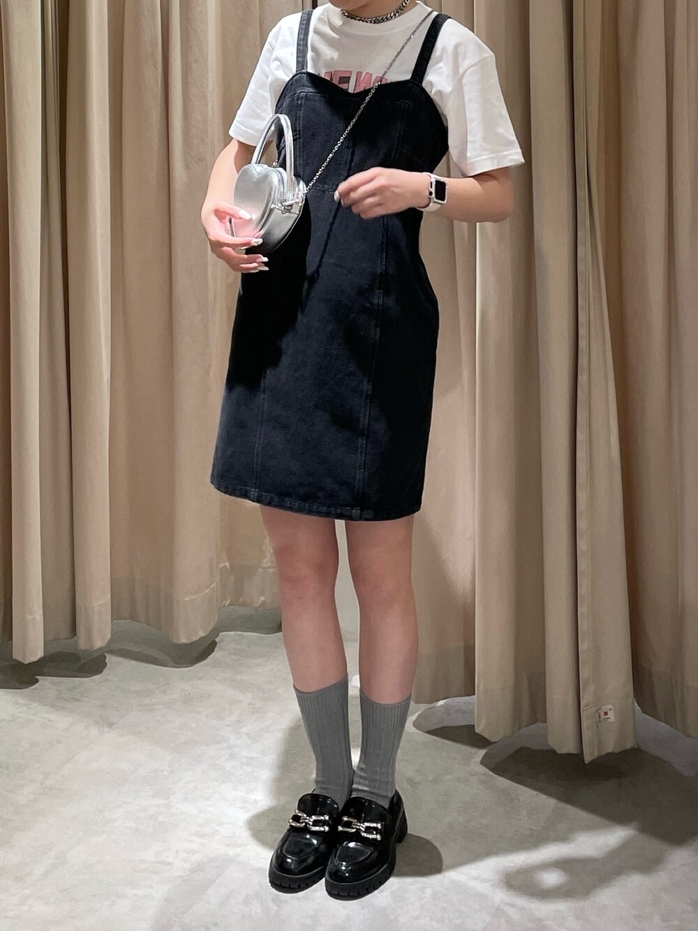 ブラック系のワンピース、ホワイト系のTシャツ/カットソー、シルバー系のショルダーバッグを着用したレディースの春コーディネートの4枚目の写真