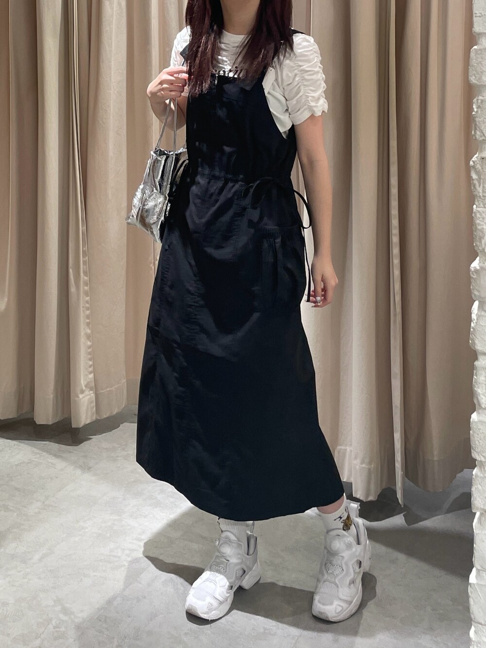 ブラック系のワンピース、シルバー系のショルダーバッグ、ホワイト系のTシャツ/カットソーを着用したレディースの春コーディネートの4枚目の写真
