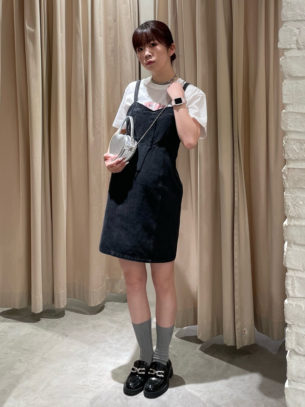 ブラック系のワンピース、ホワイト系のTシャツ/カットソー、シルバー系のショルダーバッグを着用したレディースの春コーディネートの2枚目の写真