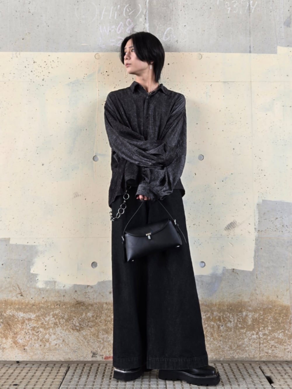 ブラック系のデニムパンツ、ブラック系のシャツ/ブラウス、ブラック系のハンドバッグを着用したメンズの春コーディネートの2枚目の写真