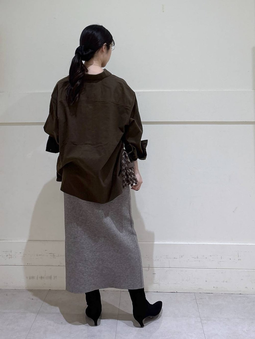 ブラウン系のショルダーバッグ、ブラウン系のシャツ/ブラウス、ベージュ系のスカートを着用したレディースの冬コーディネートの2枚目の写真