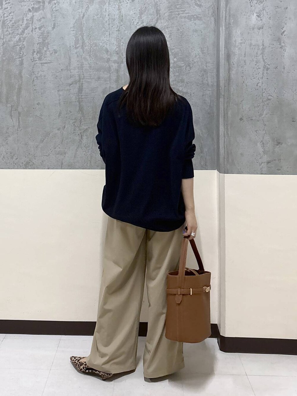 ベージュ系のその他パンツ、イエロー系のハンドバッグ、ブルー系のニット/セーターを着用したレディースの秋コーディネートの3枚目の写真