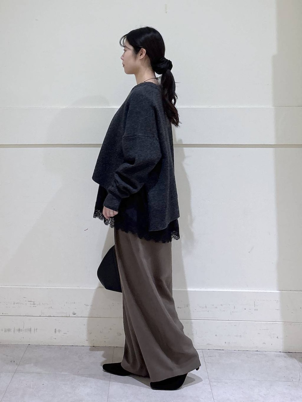 ブラック系のトートバッグ、ブラウン系のスラックス、ブラック系のシャツ/ブラウスを着用したレディースの冬コーディネートの2枚目の写真