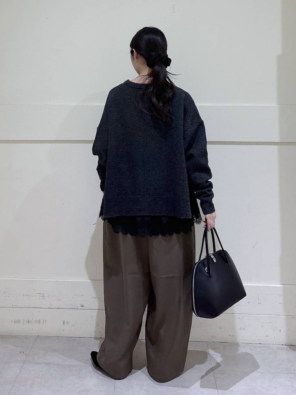 ブラック系のトートバッグ、ブラウン系のスラックス、ブラック系のシャツ/ブラウスを着用したレディースの冬コーディネートの3枚目の写真