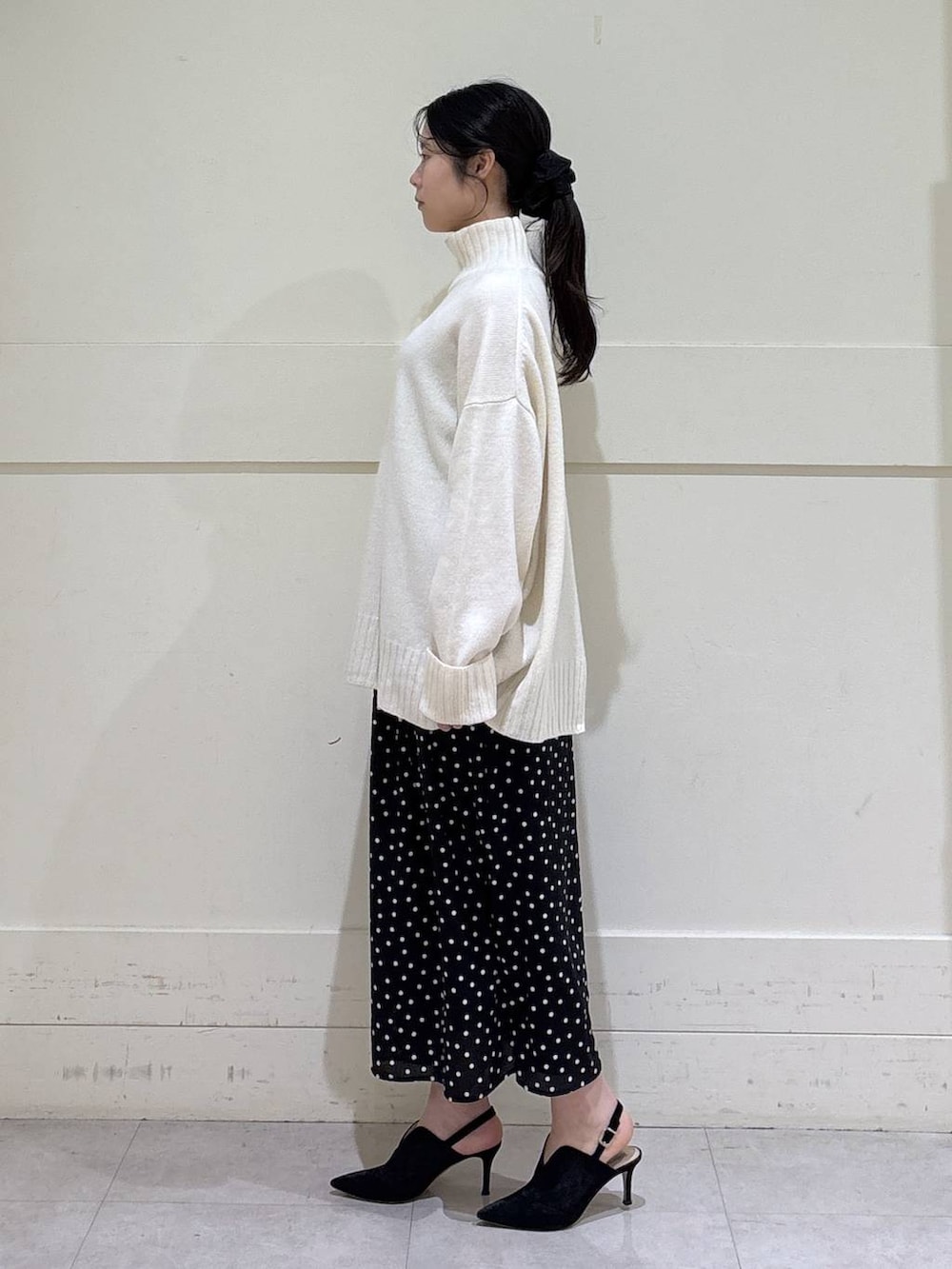 ホワイト系のニット/セーター、グレー系のチェスターコート、ブラウン系のショルダーバッグを着用したレディースの秋コーディネートの6枚目の写真