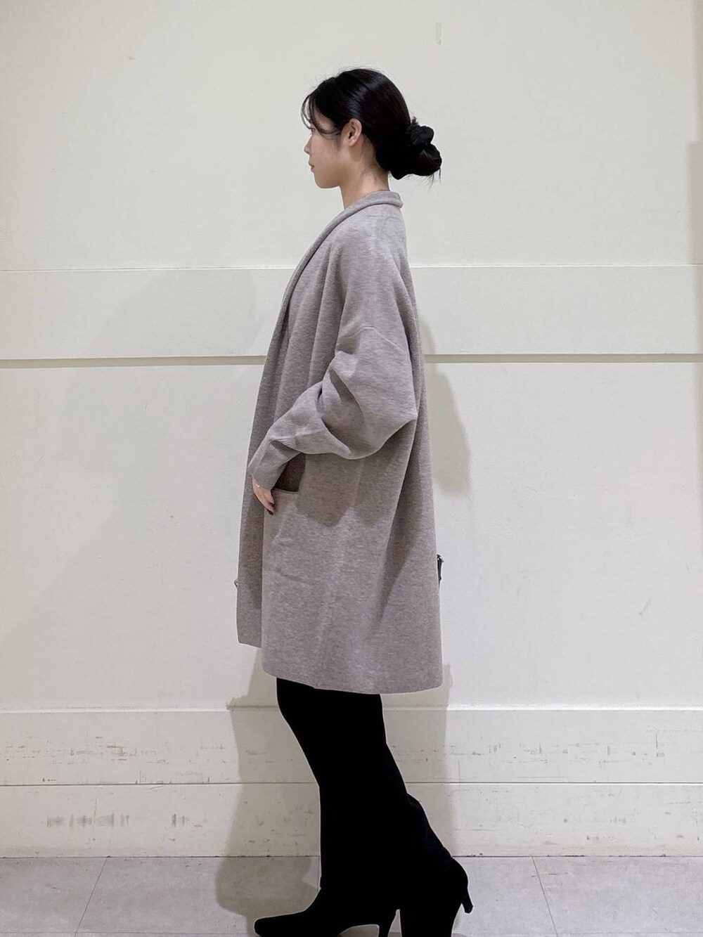 ブラック系のデニムパンツ、ベージュ系のニット/セーター、ベージュ系のカーディガン/ボレロを着用したレディースの秋コーディネートの2枚目の写真