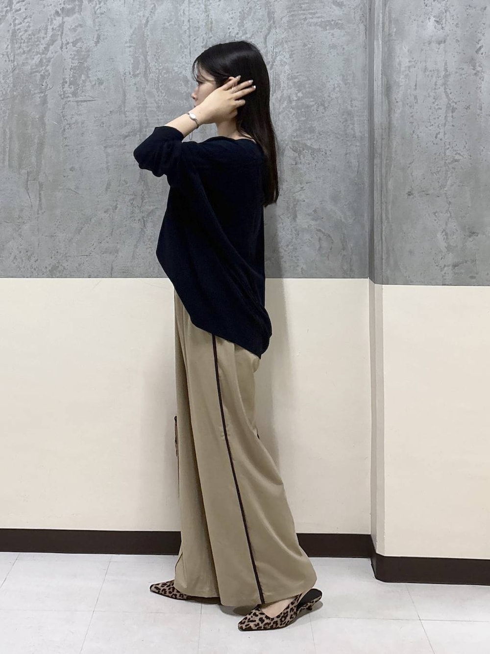 ベージュ系のその他パンツ、イエロー系のハンドバッグ、ブルー系のニット/セーターを着用したレディースの秋コーディネートの2枚目の写真