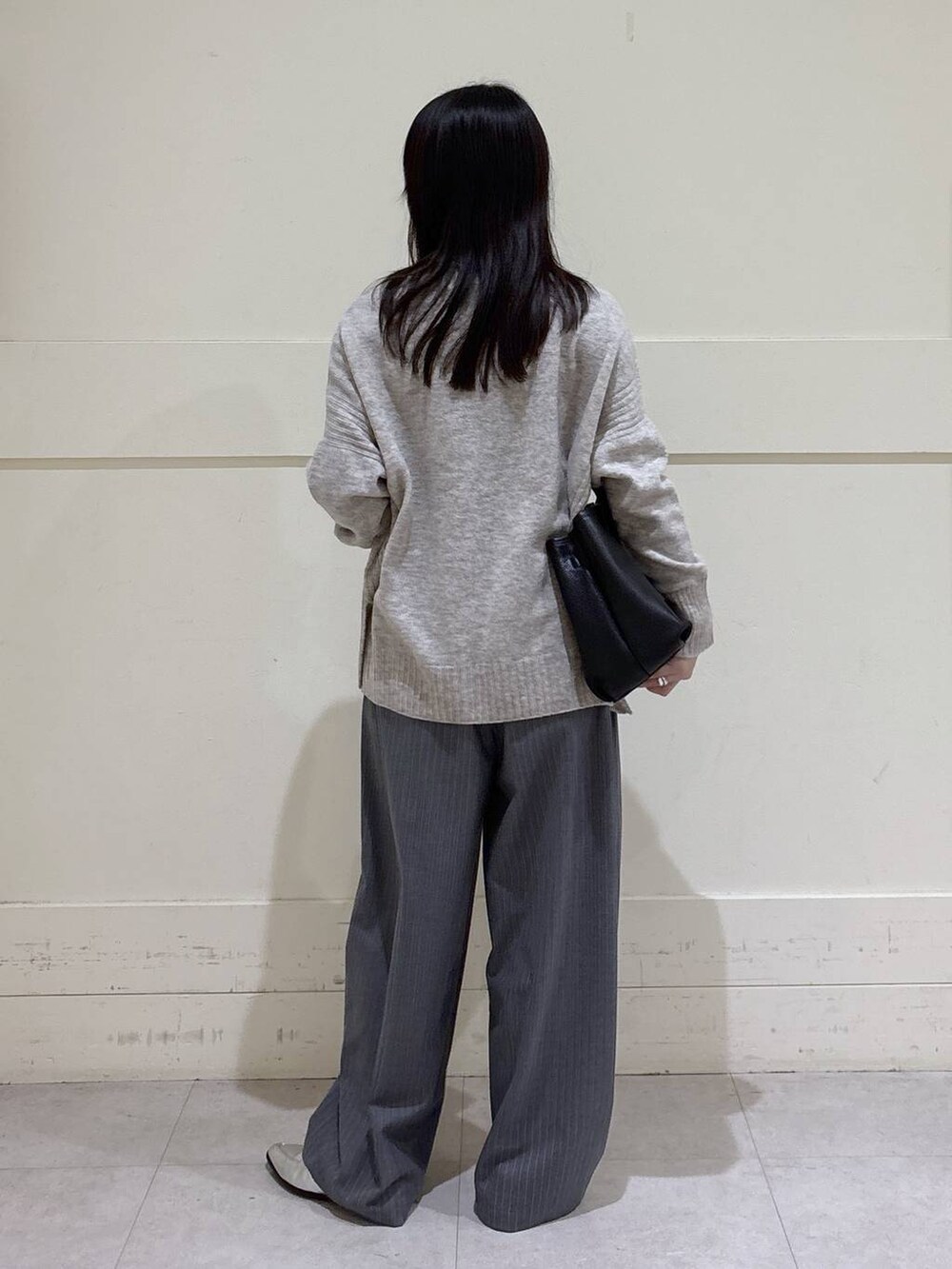 ベージュ系のニット/セーター、グレー系のその他パンツ、その他のネックレスを着用したレディースの冬コーディネートの3枚目の写真