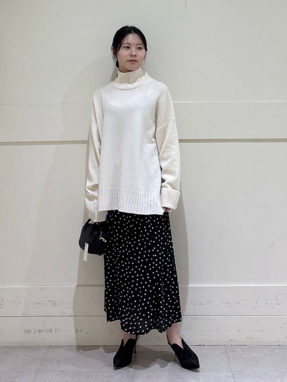 ホワイト系のニット/セーター、グレー系のチェスターコート、ブラウン系のショルダーバッグを着用したレディースの秋コーディネートの5枚目の写真