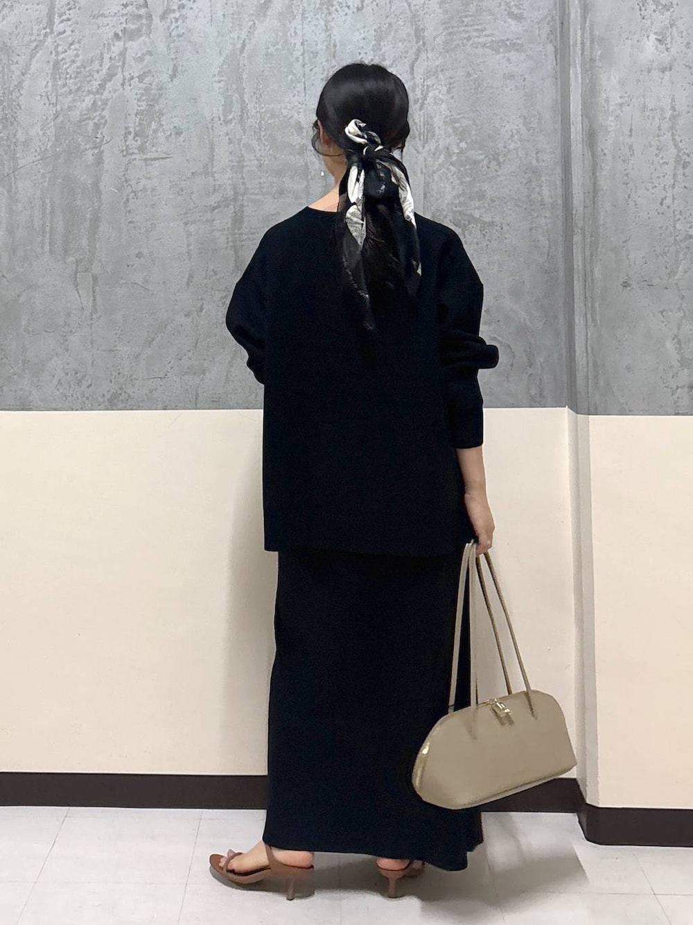 ベージュ系のトートバッグ、ブラウン系のサンダル、ブラック系のニット/セーターを着用したレディースの秋コーディネートの3枚目の写真