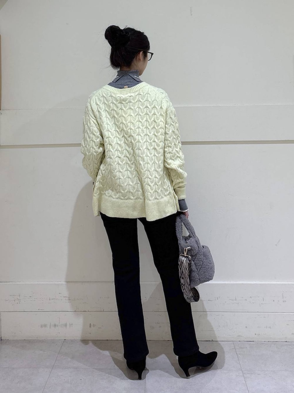 ブラック系のデニムパンツ、グレー系のトートバッグ、グレー系のニット/セーターを着用したレディースの秋コーディネートの3枚目の写真