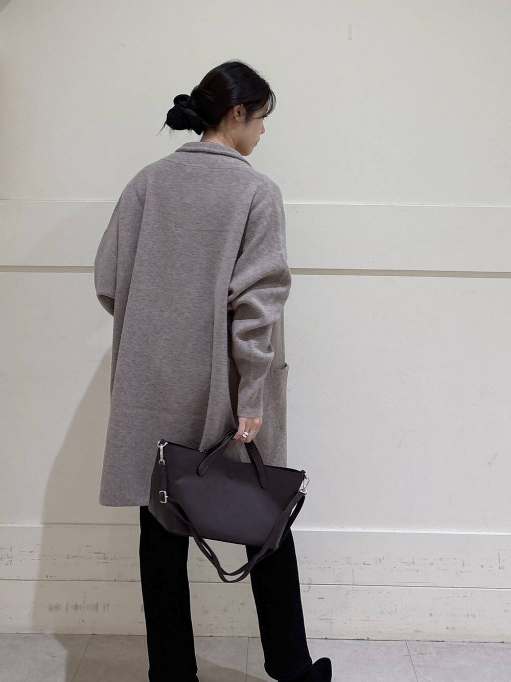 ブラック系のデニムパンツ、ベージュ系のニット/セーター、ベージュ系のカーディガン/ボレロを着用したレディースの秋コーディネートの4枚目の写真