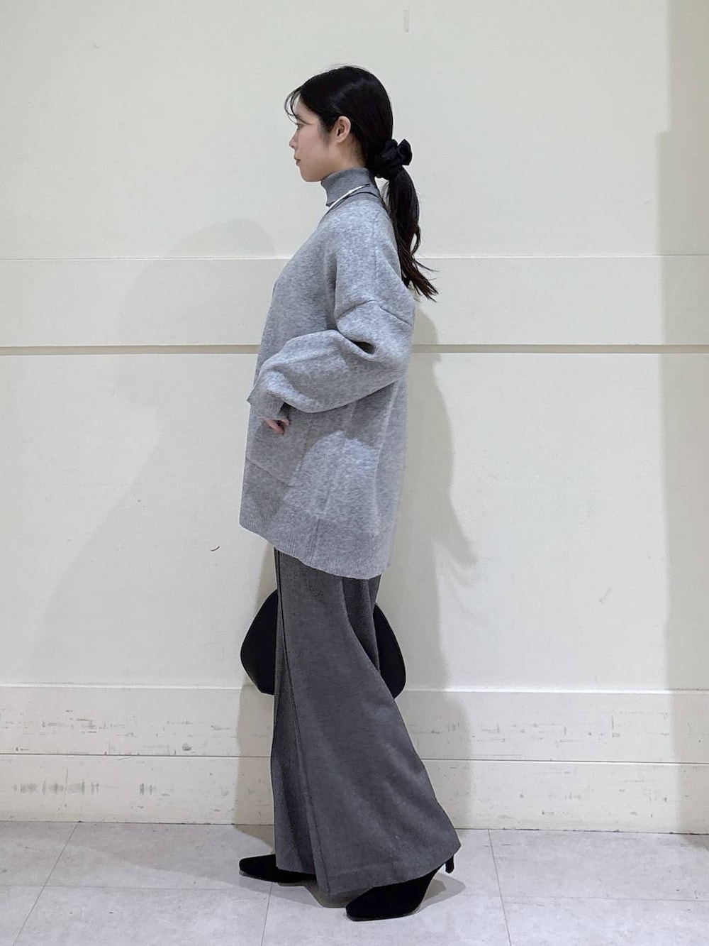 ブラック系のトートバッグ、グレー系のニット/セーター、グレー系のカーディガン/ボレロを着用したレディースの冬コーディネートの2枚目の写真