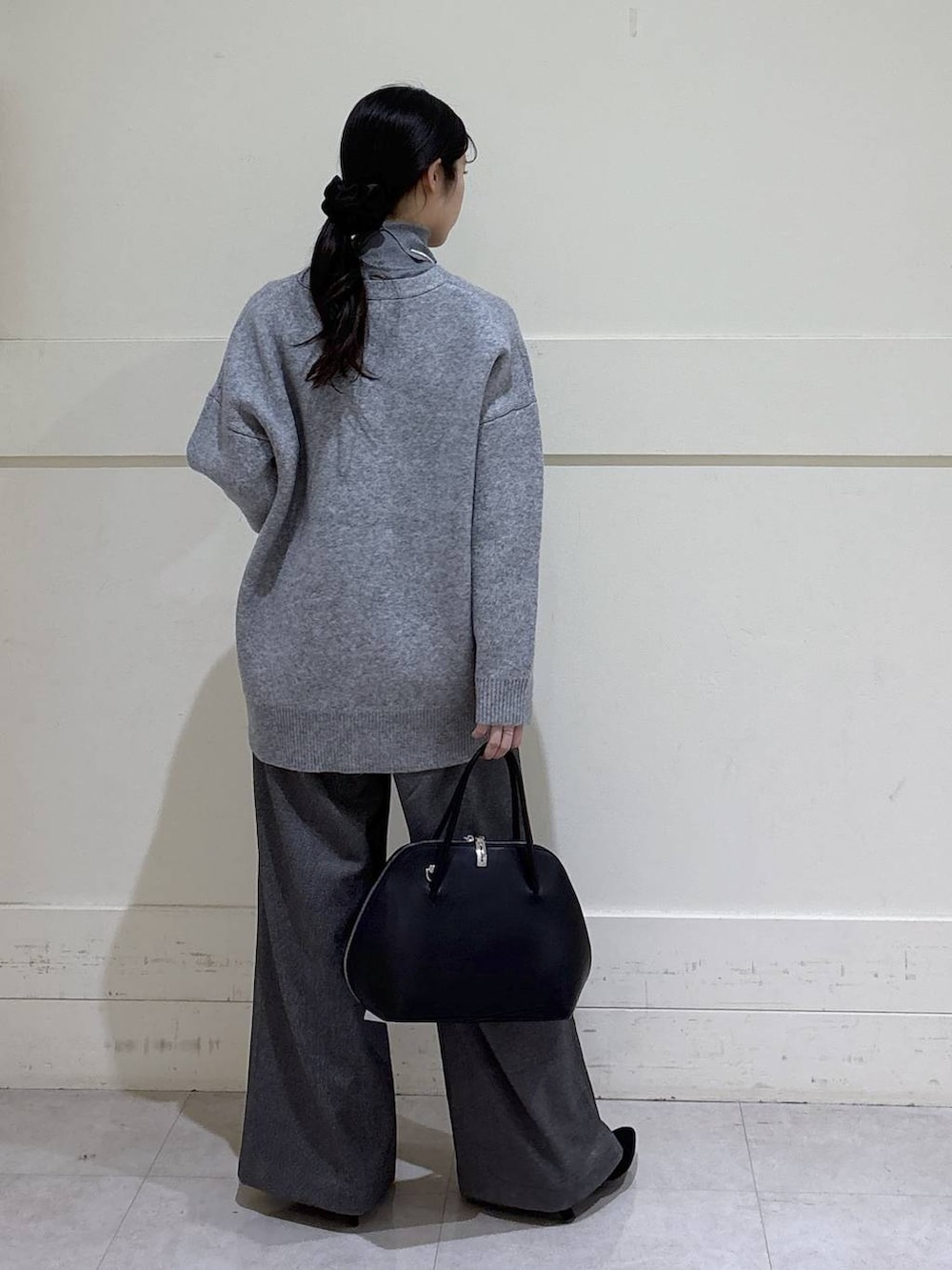 ブラック系のトートバッグ、グレー系のニット/セーター、グレー系のカーディガン/ボレロを着用したレディースの冬コーディネートの3枚目の写真