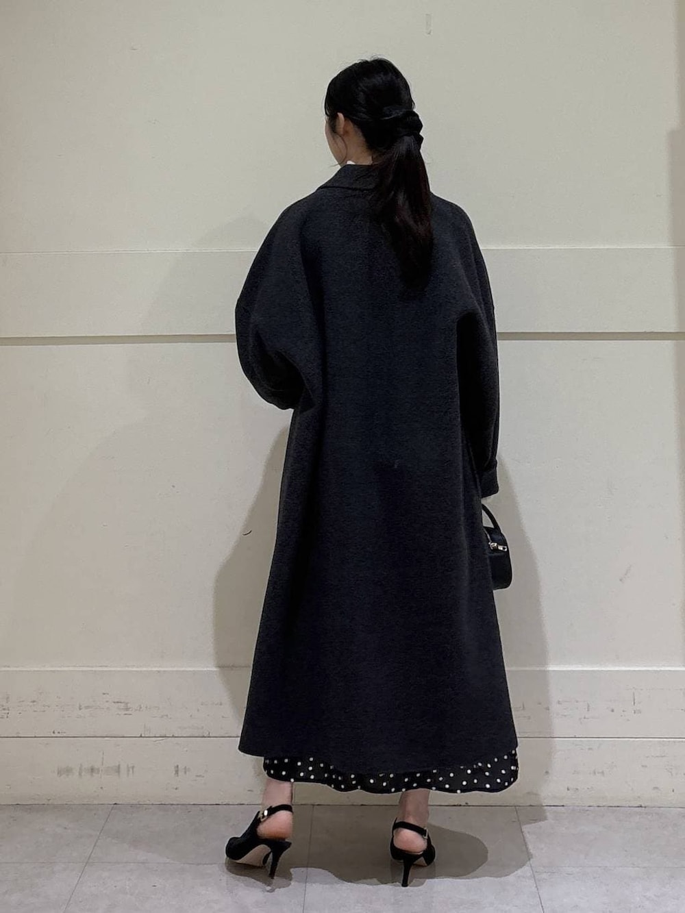 ホワイト系のニット/セーター、グレー系のチェスターコート、ブラウン系のショルダーバッグを着用したレディースの秋コーディネートの3枚目の写真